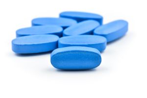 Generic viagra blue pills on white and black background.